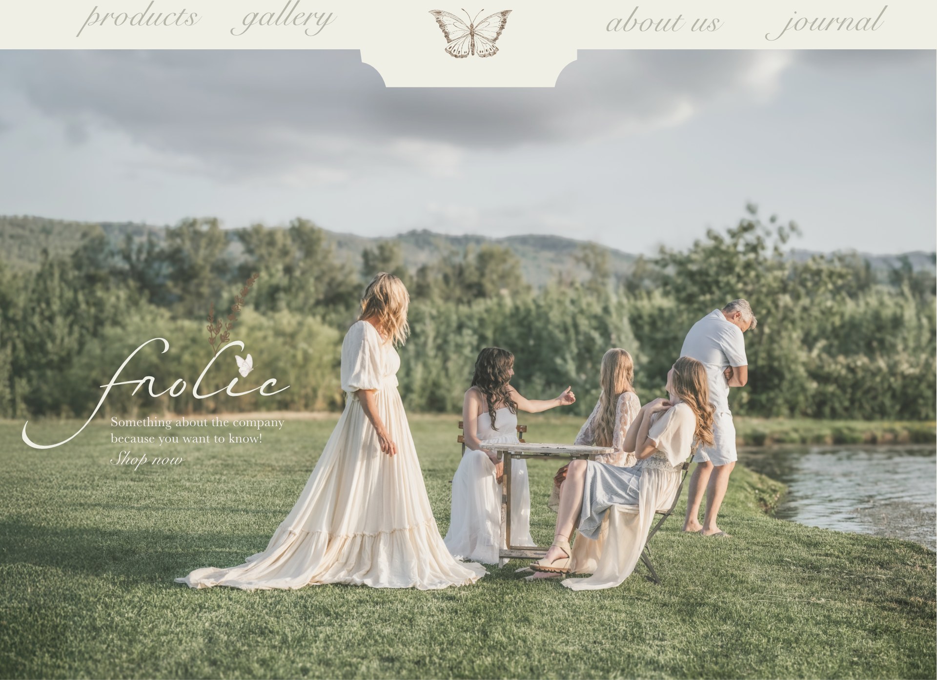 Frolic — something about the company, because you want to know. Friends in flowing cream dresses gathered around a table in a meadow beside a pond.