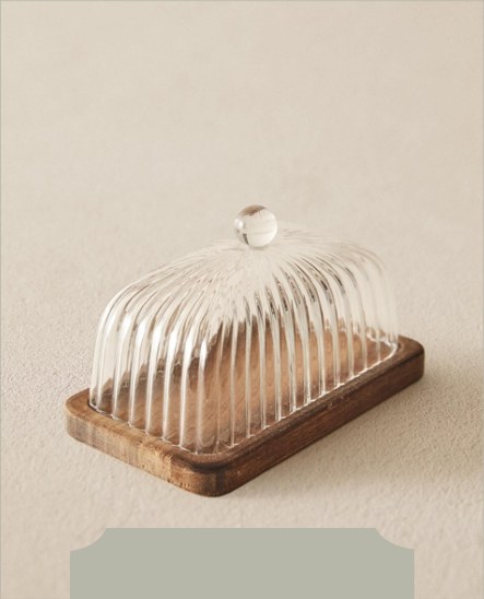 Ribbed glass butter dish on a wooden board